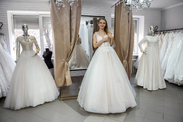 Hermosa joven novia posando en vestido de novia en el salón