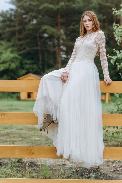 Una hermosa joven novia con un ramo de margaritas en un campo