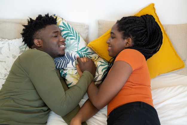 hermosa joven pareja africana se acuesta en la cama