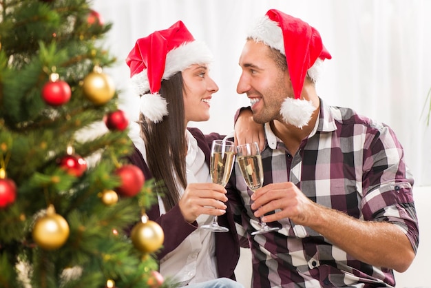Hermosa joven pareja celebrando la Navidad o el Año Nuevo con una copa de champán.