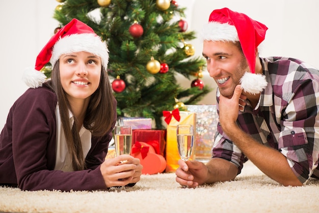 Hermosa joven pareja celebrando la Navidad o el Año Nuevo con una copa de champán.