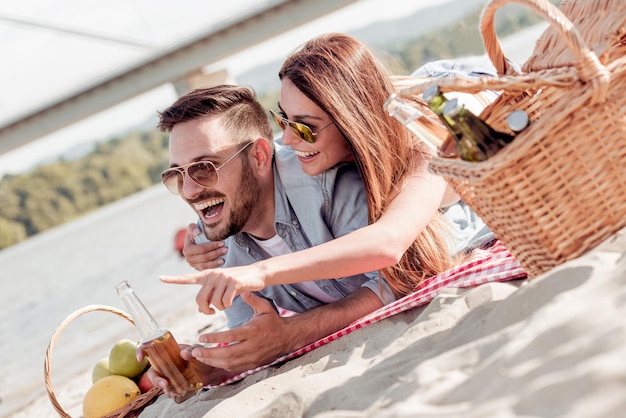 Hermosa joven pareja divirtiéndose en la playa