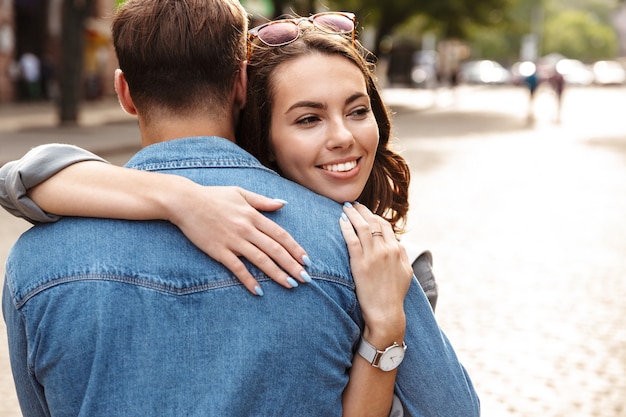 Hermosa joven pareja de enamorados al aire libre en la calle de la ciudad, abrazándose