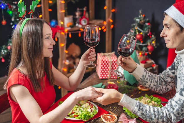 Hermosa joven pareja de enamorados está pasando una cena navideña festiva