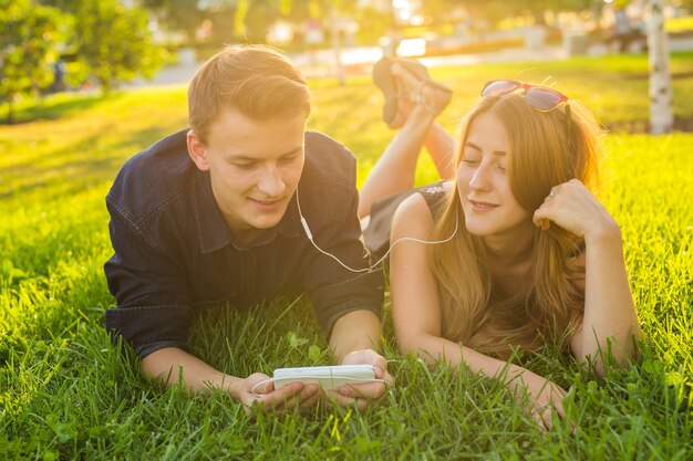 Hermosa joven pareja feliz divirtiéndose en la hierba.