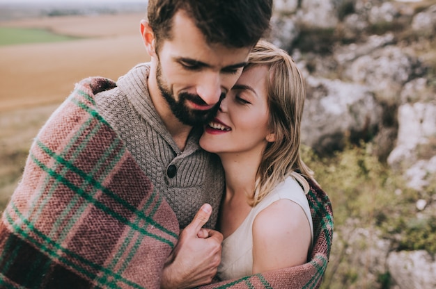 Hermosa joven pareja en un fondo de acantilado de roca