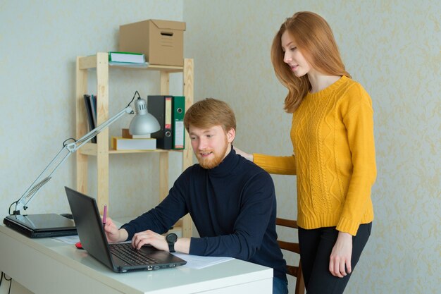 hermosa joven pareja hombre y mujer trabajando en la computadora portátil