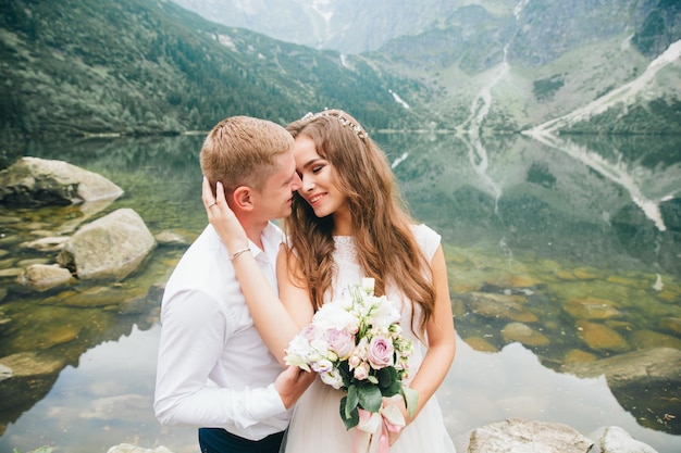 Una hermosa joven pareja en el lago en las montañas Tatra en Polonia Morskie Oko