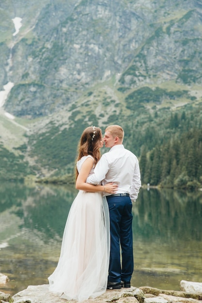 Una hermosa joven pareja en el lago en las montañas Tatra en Polonia Morskie Oko