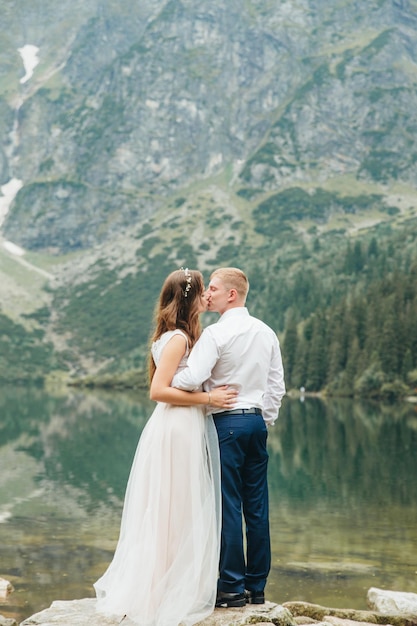 Una hermosa joven pareja en el lago en las montañas Tatra en Polonia Morskie Oko