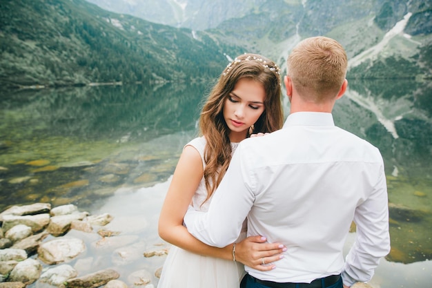 Una hermosa joven pareja en el lago en las montañas Tatra en Polonia Morskie Oko