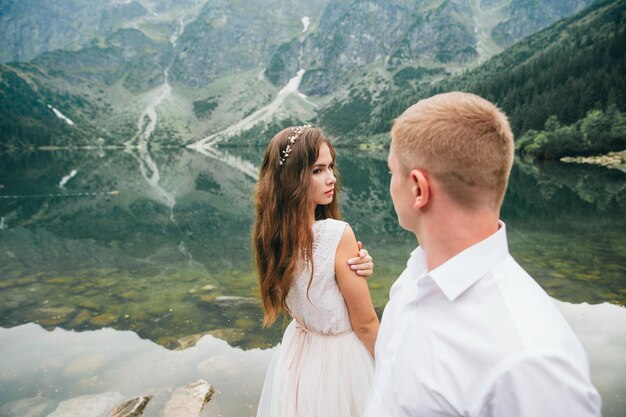 Una hermosa joven pareja en el lago en las montañas Tatra en Polonia Morskie Oko