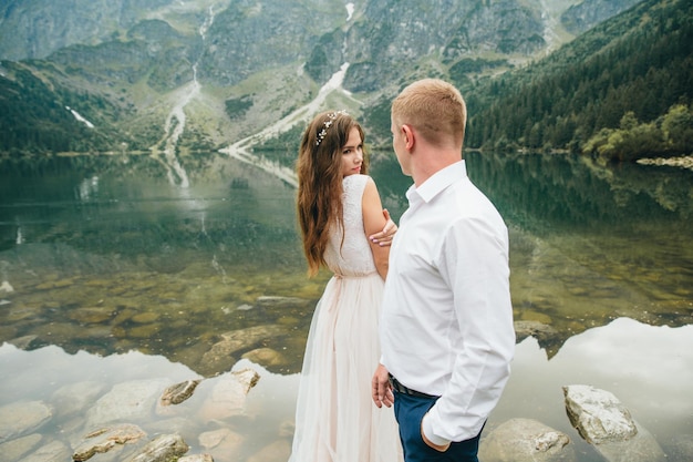 Una hermosa joven pareja en el lago en las montañas Tatra en Polonia Morskie Oko