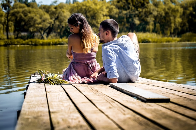 hermosa joven pareja en el muelle cerca del río