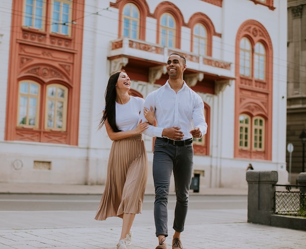 Hermosa joven pareja multiétnica caminando por la calle