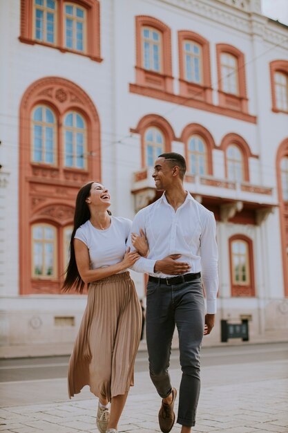 Hermosa joven pareja multiétnica caminando por la calle