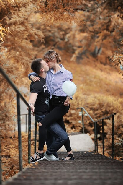 Hermosa joven pareja en un paseo por el parque otoño