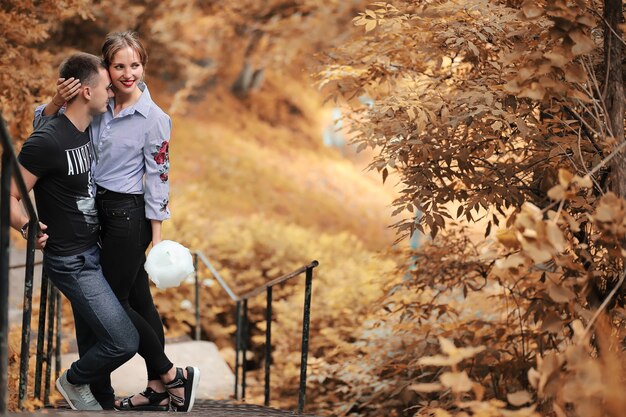 Hermosa joven pareja en un paseo por el parque otoño