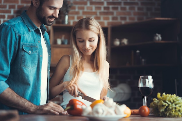 Hermosa joven pareja preparando una comida saludable juntos mientras pasan tiempo libre en casa