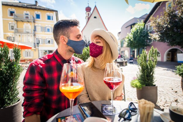 Hermosa joven pareja sentada en un bar restaurante y tomando una copa Dos amantes que datan al aire libre