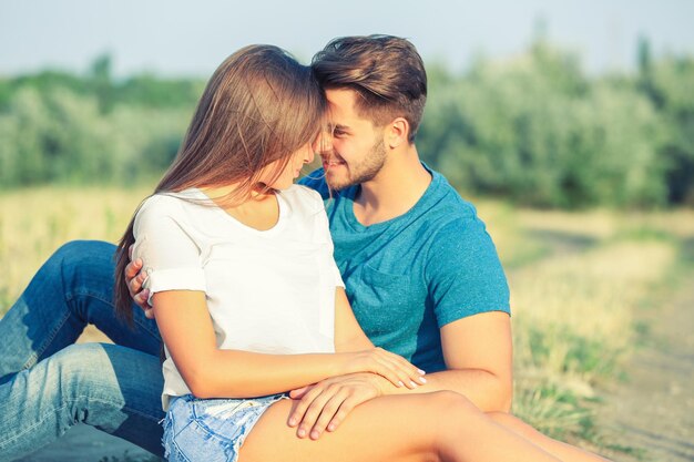 Hermosa joven pareja sentados juntos en un prado