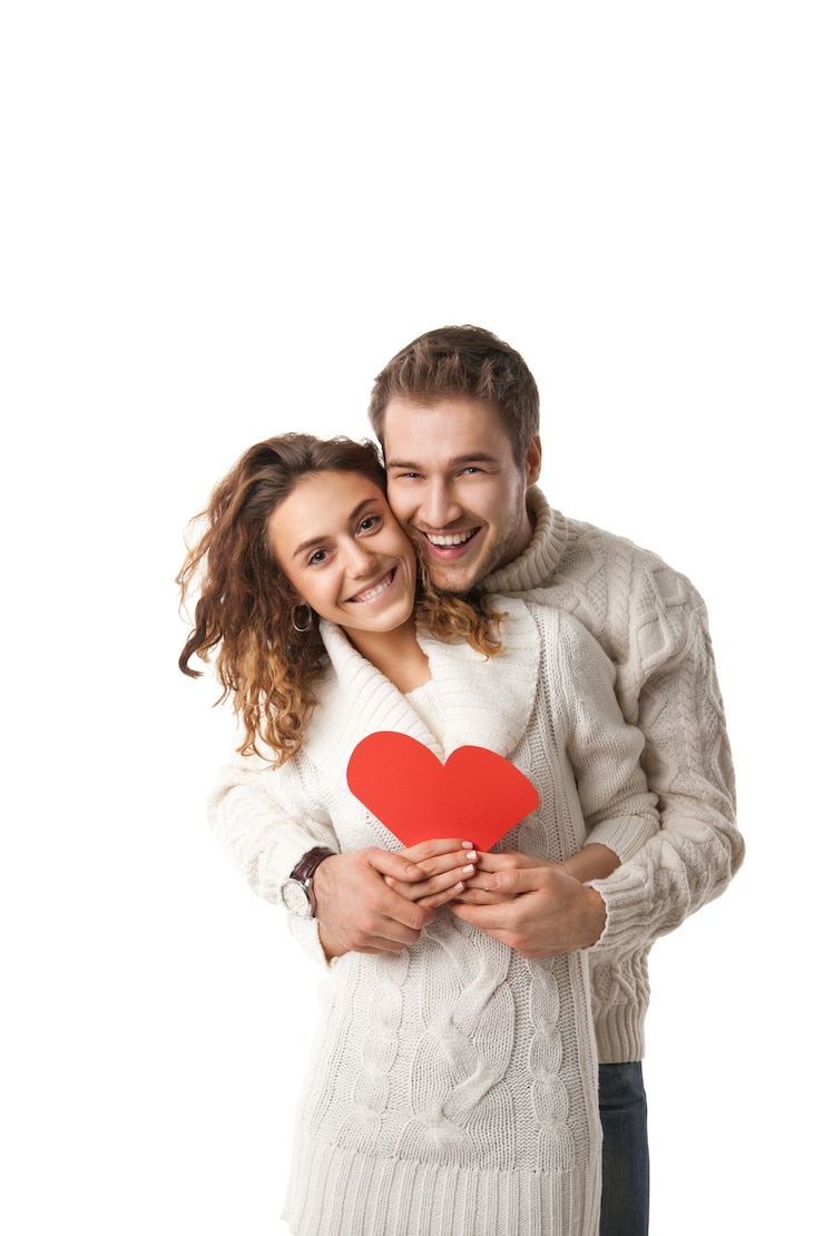 Foto hermosa joven pareja sosteniendo un corazón rojo aislado sobre fondo blanco.