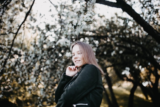 hermosa joven en un parque floreciente en primavera