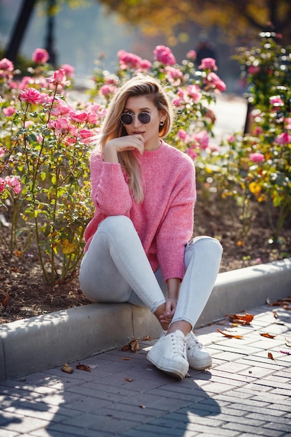 Hermosa joven en un paseo por la ciudad de otoño Hermosa mujer en un suéter Retrato de moda elegante mujer bonita al aire libre Mujer joven divirtiéndose en la ciudad Moda callejera