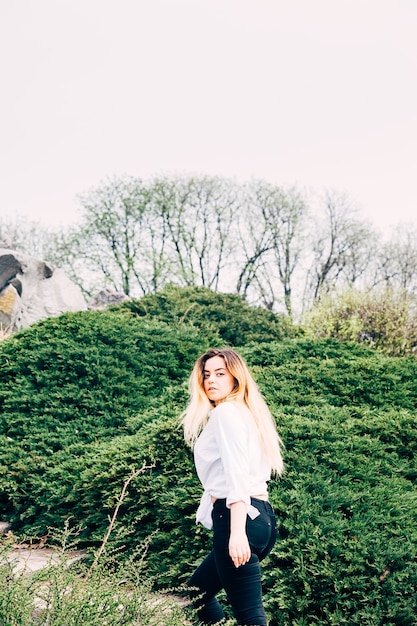 Una hermosa joven de pelo largo caminando en un parque