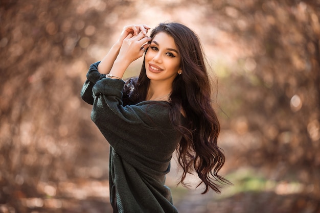 Hermosa joven con el pelo largo en un paseo por el bosque de otoño