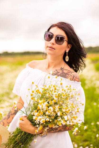 Hermosa joven con pelo rojo rizado en campo de manzanilla