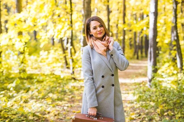 Hermosa joven de pie en el parque otoño