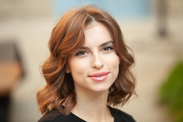 La hermosa joven con la piel blanca y la hermosa sonrisa mujer europea en la calle