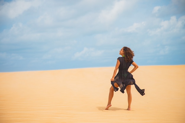 Hermosa joven posando en la arena del desierto