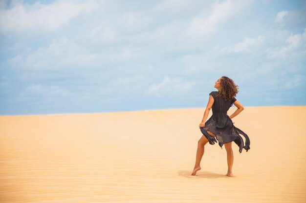 Hermosa joven posando en la arena del desierto