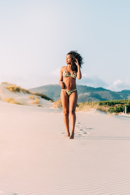 Hermosa joven posando en la arena de la playa