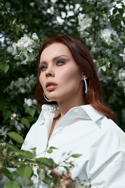 Hermosa joven posando cerca del árbol de flor de cerezo