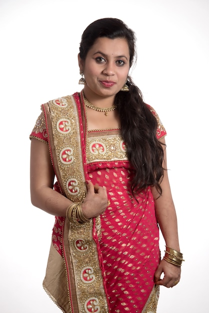 Hermosa joven posando en sari tradicional indio en blanco.