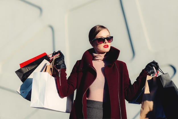 Foto hermosa joven está posando con sus bolsas de compras