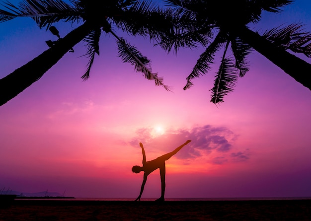 Hermosa joven practic yoga en la playa. Ejercicio temprano en la mañana. amanecer