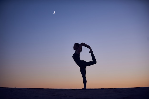 Foto hermosa joven practica yoga asana natarajasana