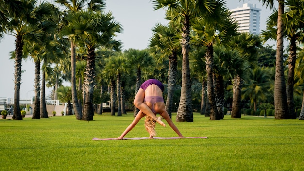 Hermosa joven practica yoga en la playa. ejercicio temprano en la mañana