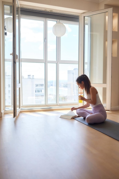 Hermosa joven practicando yoga en casa