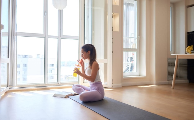 Hermosa joven practicando yoga en casa