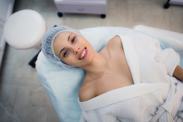 Hermosa joven preparándose para el tratamiento de la piel de la cara