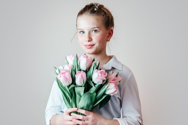 Hermosa joven con un ramo de flores de tulipán rosa