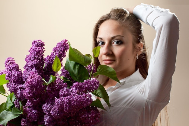 Hermosa joven con un ramo de lilas