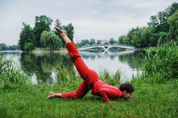 Hermosa joven realizando ejercicios de yoga en el lago Ashtanga namaskar