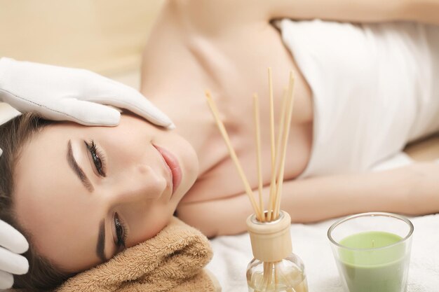 Hermosa joven recibiendo un tratamiento facial en el salón de belleza