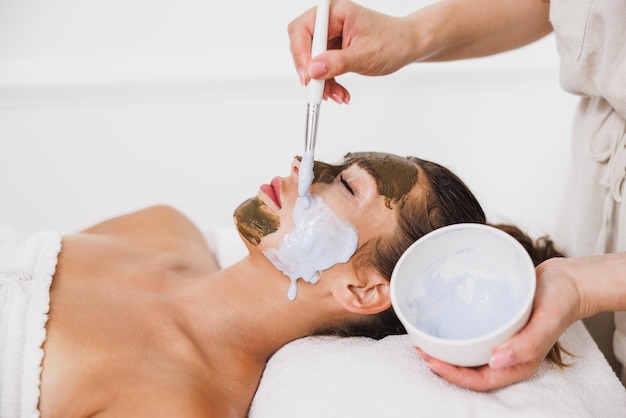 Hermosa joven recibiendo un tratamiento de mascarilla hidratante en el spa.